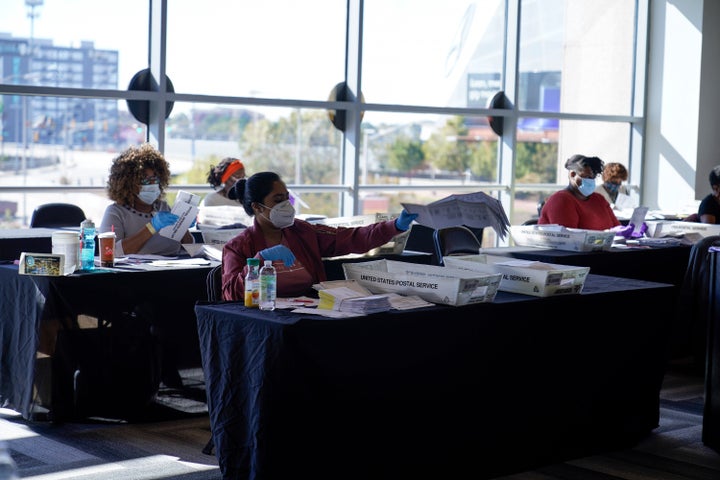 Election inspectors look over ballots as vote counting in the general election continues at State Farm Arena in Atlanta on Wednesday, Nov. 4.