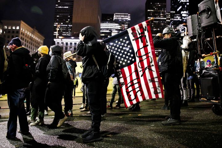 Διαδηλωτής κρατά ανάποδα την αμερικάνικη σημαία κατά τη διάρκεια πορείας με αίτημα «καταμέτρηση κάθε ψήφου, Προστασία για το κάθε πολίτη»