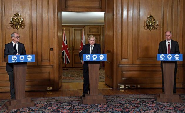 Johnson, centre, stands with chief medical officer Professor Chris Whitty, right, and chief scientific adviser Sir Patrick Vallance at a press conference in 10 Downing Street on Saturday