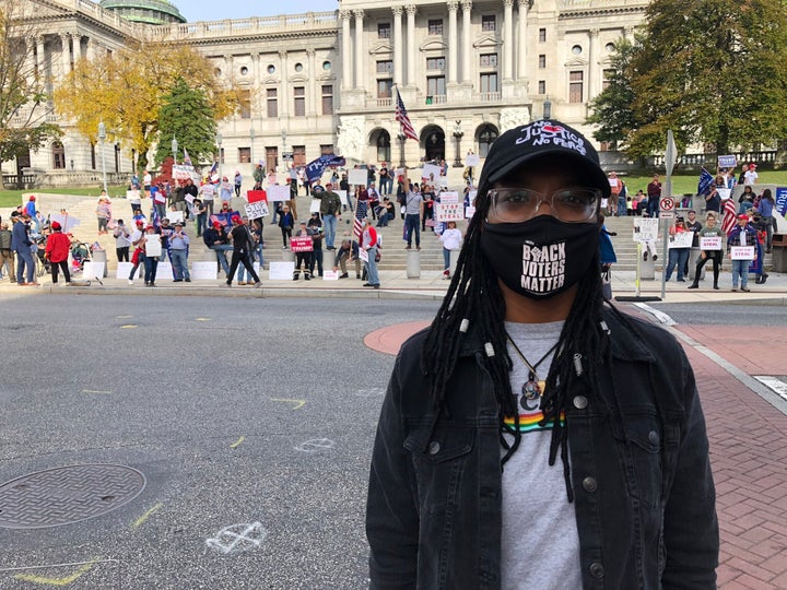 Symphany Jones, 25, stands across the street from a pro-Trump "Stop the Steal" rally Thursday in Harrisburg, Pennsylvania.