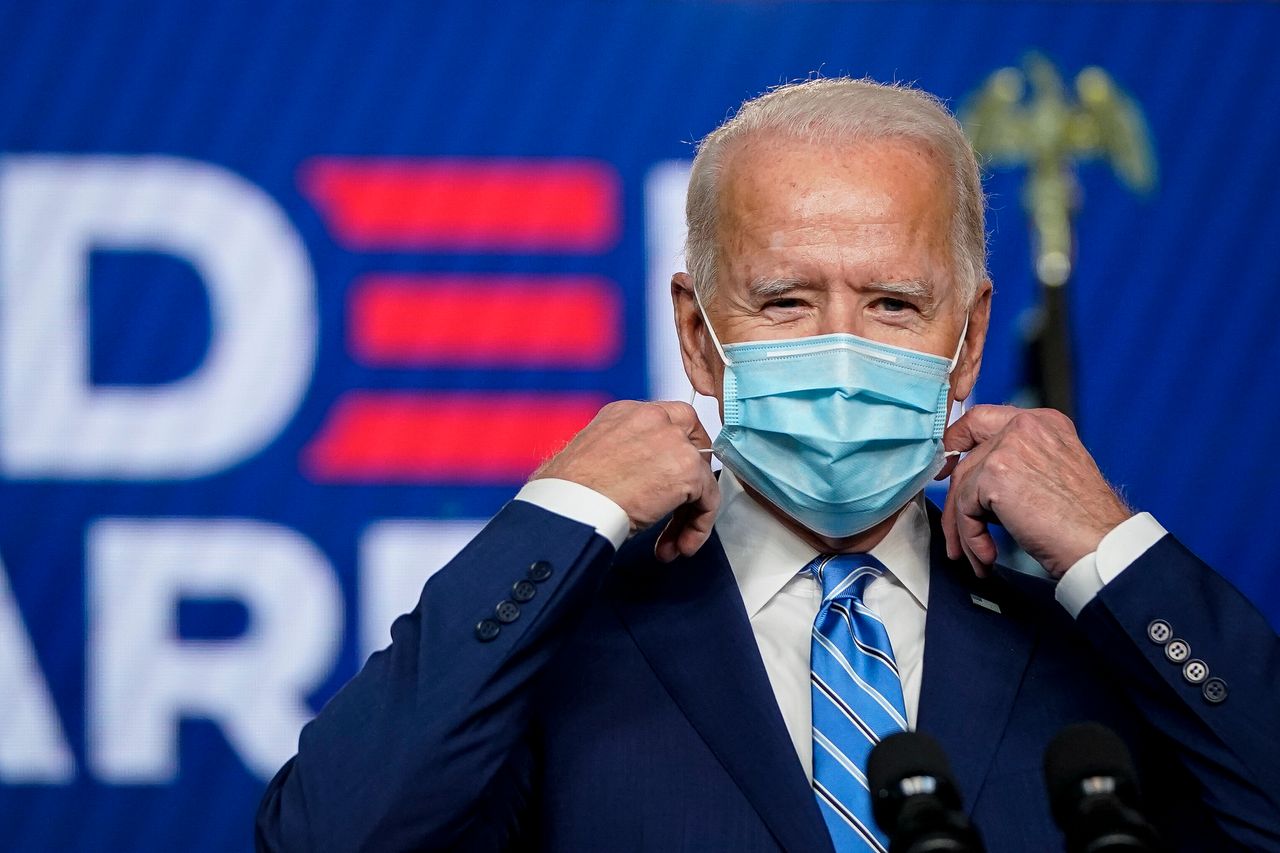 Joe Biden takes his face mask off as he arrives to speak one day after Americans voted in the presidential election.