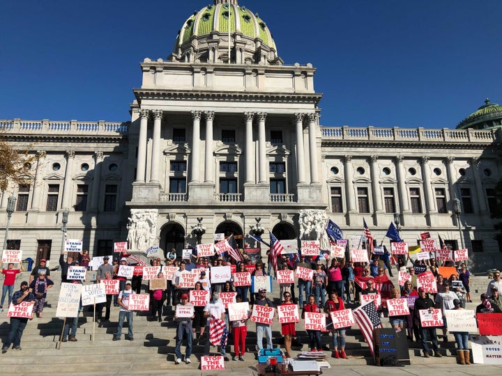 Supporters of President Donald Trump pose for a photo during a "Stop The Steal" rally on the steps of the Pennsylvania State