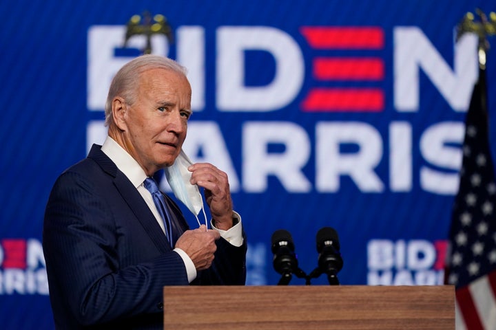 Joe Biden removes his face mask as he arrives to speak on Friday.