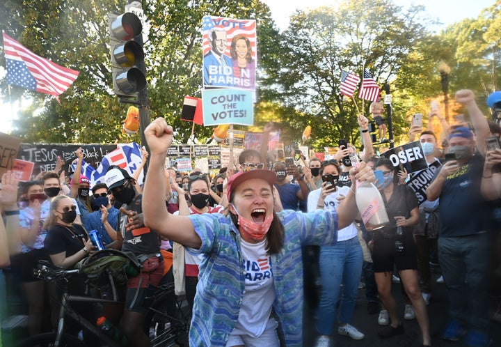 A woman dances after spraying prosecco onto the crowd as people celebrate on Black Lives Matter Plaza across from the White House in Washington, D.C. on Nov. 7. 