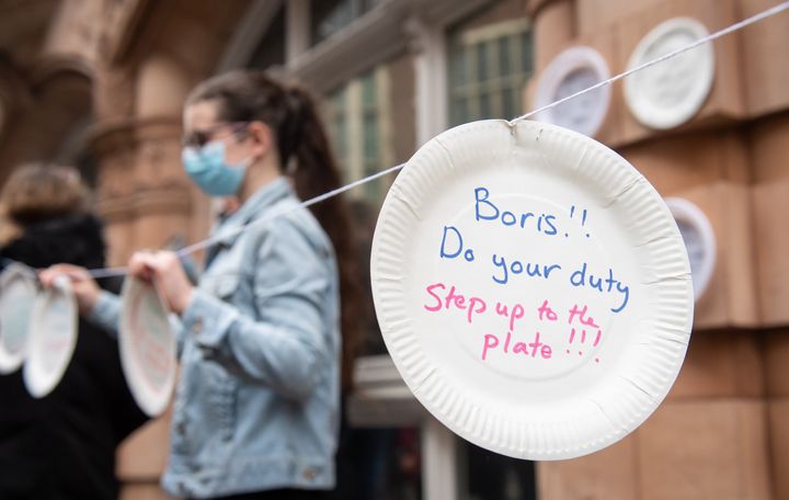 Protestors hang up paper plates carrying slogans calling for the government to extend free school meals provision, outside the Department for Education, in Westminster, London. Local councils and businesses are continuing to pledge free food for children in need during this week's half term break after the Government defeated a Labour motion to extend free school meals provision in England over the holidays.
