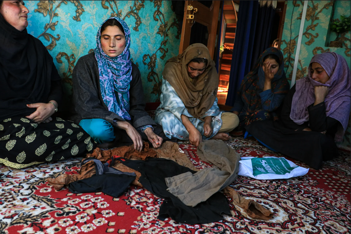 Rifleman Shakir Manzoor Waghay's family members cry while showing his clothes that were found after he was kidnapped. 