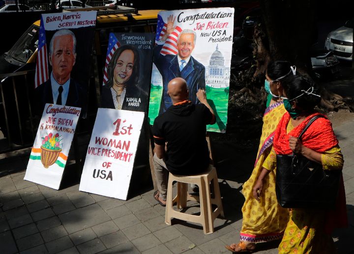 Indian art teacher Sagar Kambli on Sunday makes paintings of U.S. President-elect Joe Biden and the vice president-elect outside his art school in Mumbai, India, which has been closed due to the COVID-19 pandemic.