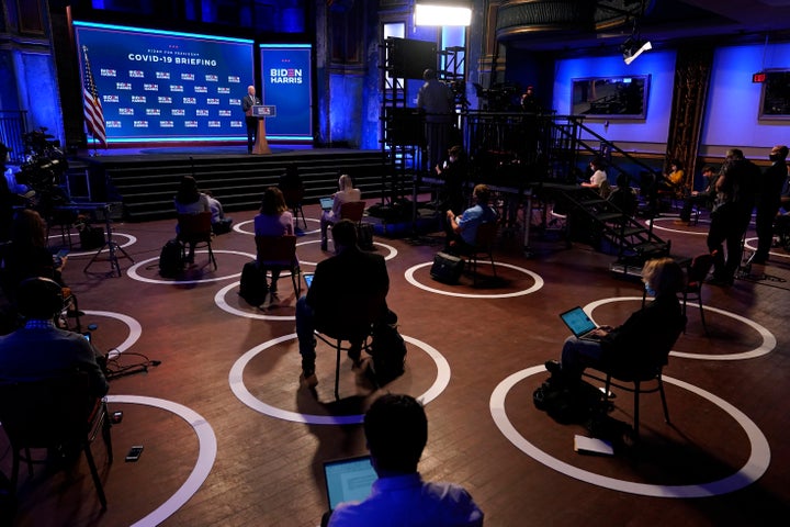 In this Sept. 1, 2020, file photo journalists sit in socially-distant circles as Democratic presidential candidate former Vice President Joe Biden speaks after participating in a coronavirus vaccine briefing with public health experts in Wilmington, Del. (AP Photo/Patrick Semansky, File)