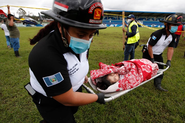 First responders rescue a girl who was buried by a massive, rain-fueled landslide Saturday in the aftermath of Tropical Storm