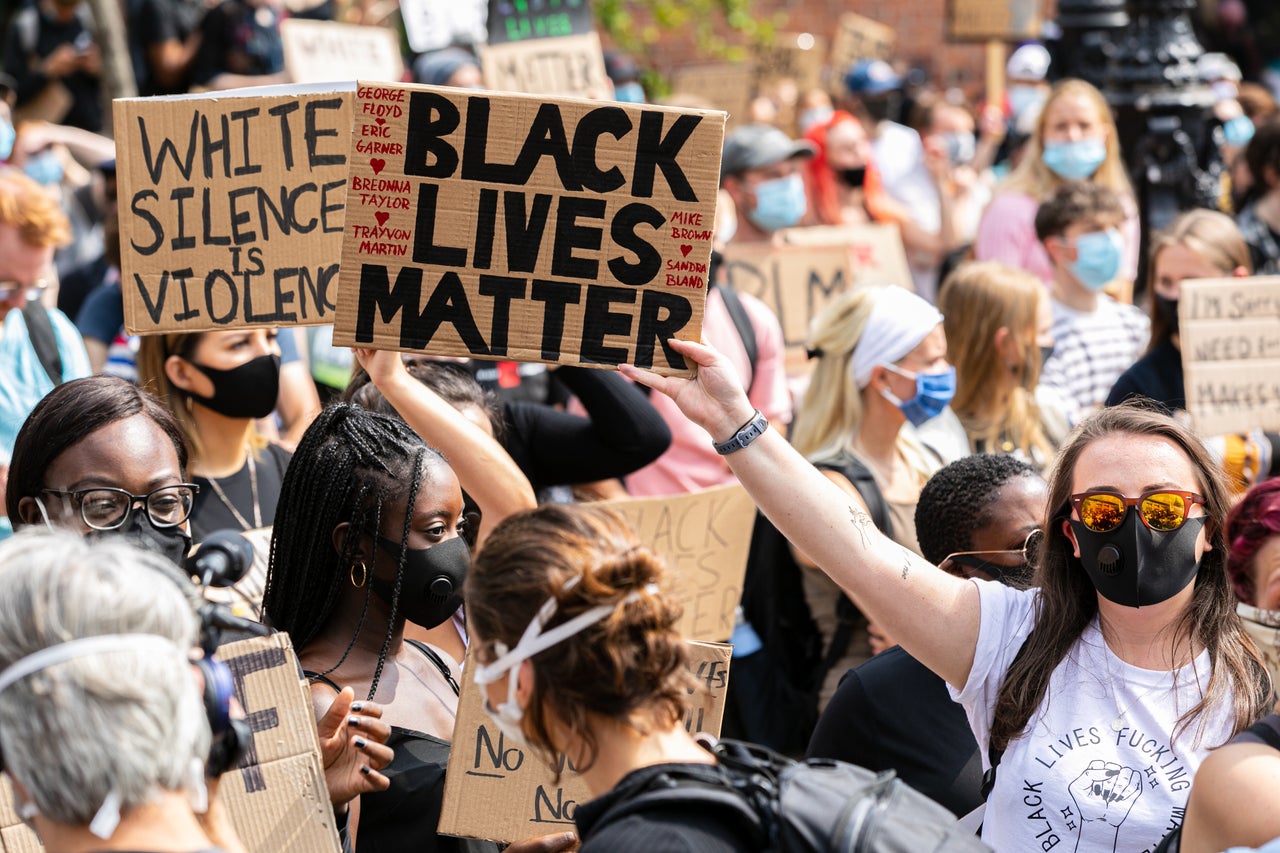 Protesters hold placards as they march during a demonstration in Millennium square.