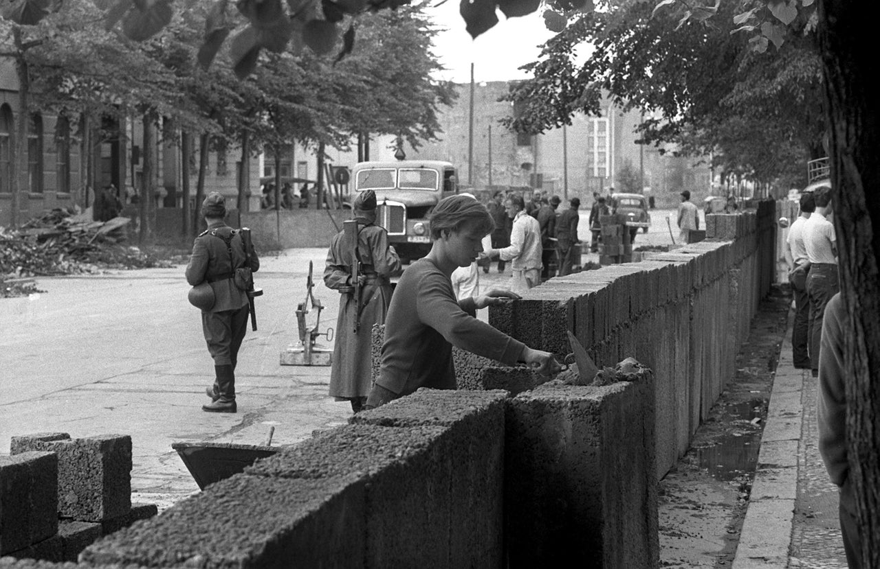 Εργάτες βάζουν τα πρώτα τούβλα. Κανείς δεν περίμενε ότι το τείχος θα χώριζε για δεκαετίες έναν λαό και μια Ευρώπη.