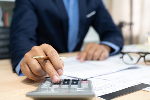 A financial expert calculates a mortgage down payment in this undated stock photo. Besides the financial...