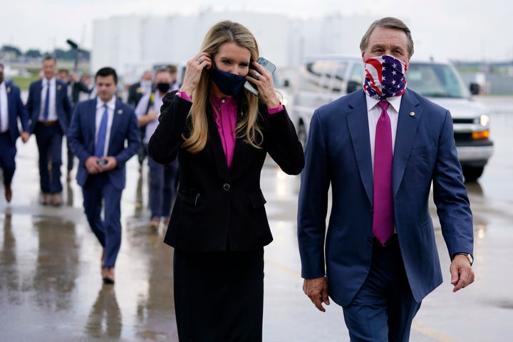 Sen. Kelly Loeffler (R-Ga.) walks with Sen. David Perdue (R-Ga.) in July in Atlanta. Both will be competing to hold on to their seats in the January runoff elections.