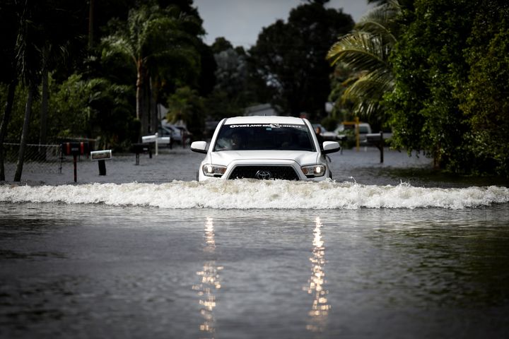 A commuter drives in floodwaters caused by Tropical Storm Eta in Davie, Florida.