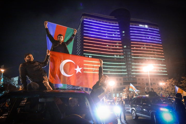 BAKU, AZERBAIJAN - NOVEMBER 10: Azerbaijani people celebrate the deal reached to halt fighting over the Nagorno-Karabakh region, in Baku, Azerbaijan on November 10, 2020. In a televised address, Azerbaijani President Ilham Aliyev announced the end of the Karabakh conflict between Baku and Yerevan with the new agreement. (Photo by Resul Rehimov/Anadolu Agency via Getty Images)