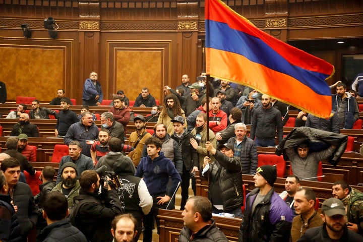 Demonstrators with an Armenian national flag protest against an agreement to halt fighting over the Nagorno-Karabakh region, 