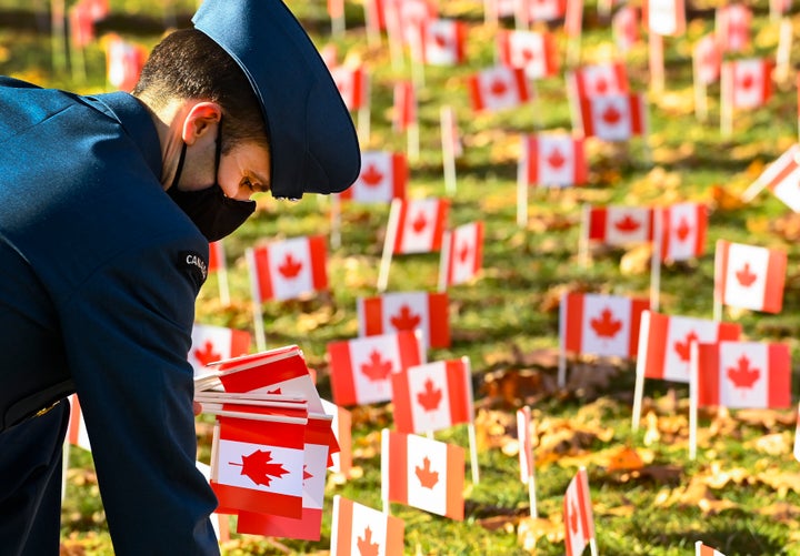 Un militaire dépose des drapeaux canadiens à la veille du jour du souvenir au Sunnybrook Veterans Centre à Toronto. 