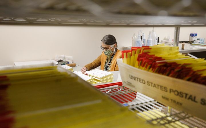 Mail-in ballots in containers from the U.S. Postal Service wait to be processed by election workers in Salt Lake City on Oct. 29, 2020.