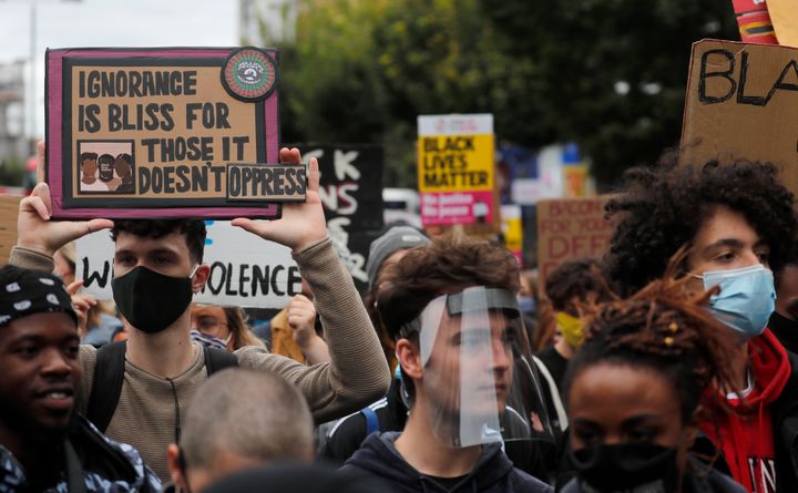 Black Lives Matter protesters hold up posters as they march through Notting Hill during the "Million People March" through central London in August 2020.