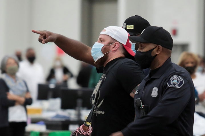 Police escort a poll challenger out after he refused to leave due to room capacity at the TCF Center in Detroit on Nov. 4, 2020. 