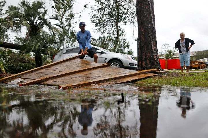 Joseph Howat clears a fence damaged by Hurricane Michael at his business in Panama City Beach, Florida.