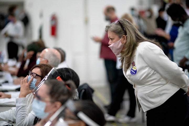 Jacqueline Zaplitny, a Republican election challenger, watches as election inspectors count votes into the early morning hours of Nov. 4, 2020, at the central counting board in Detroit.