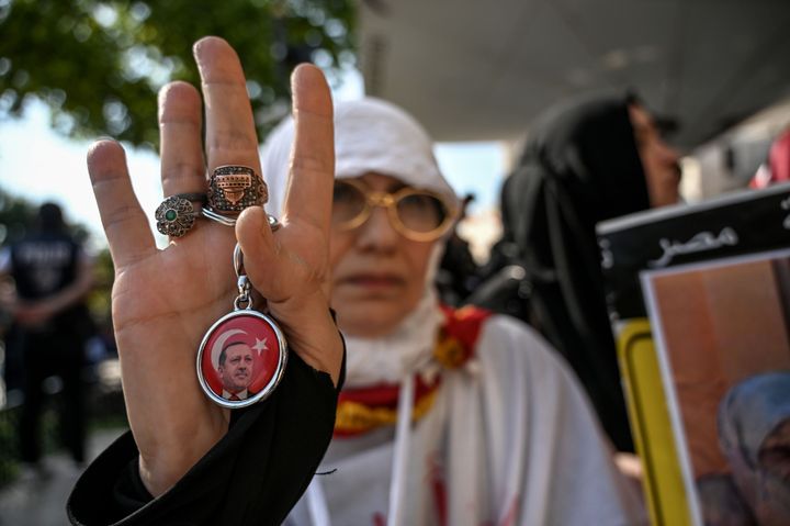 18 Ιουλίου 2019 Μια γυναίκα από τη Συρία που μαζί με χιλιάδες άλλους συμμετείχε στις προσευχές με αφορμή τον θάνατο του Μόρσι στην Κωνσταντινούπολη. Η γυναίκα χαιρετά κατά το πρότυπο των Αδελφών Μουσουλμάνων της Αιγύπτου. Τα δάκτυλα είναι ανοιχτά και ο αντίχειρας διπλωμένος, κάνει δηλαδή το σήμα της Ράμπια.