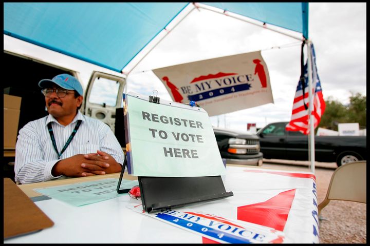 Wilson Deschine sits at the "be my voice" voter registration stand at the Navajo Nation annual rodeo in Window Rock, Arizona.