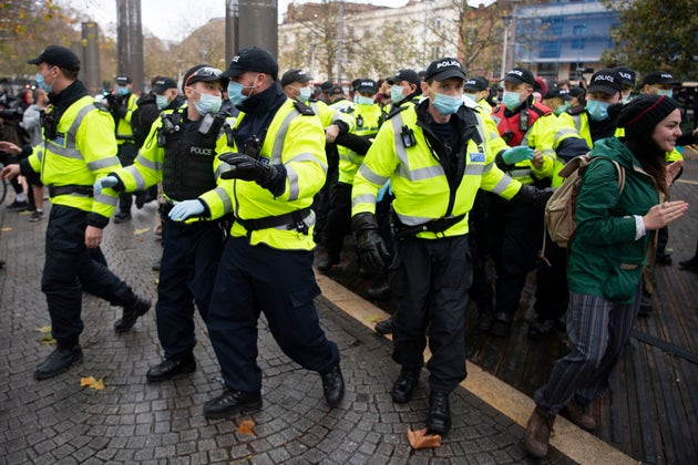 Police form a circle after they arrest a man during the anti-lockdown protest.