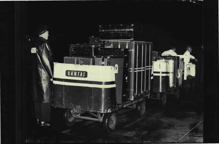 Luggage for the King of Thailand's royal tour of Australia arrived by Qantas plane from New Zealand tonight.Here security police guard the trolley loads of luggage. August 25, 1962. 