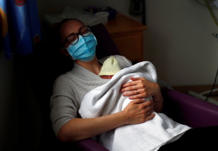 A mom rests with her premature baby during the COVID-19 pandemic. 