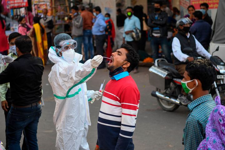 A medical worker collects a swab sample from a man for a RT-PCR test for Covid-19 in New Delhi on November 17, 2020.
