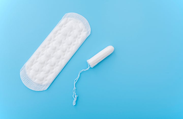Sanitary napkin and menstruation tampon on blue background, concept picture about women's menstruation cycle, top view