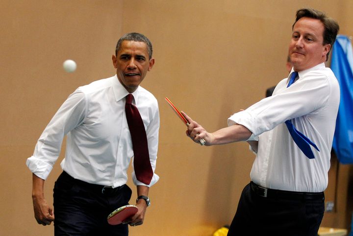 Barack Obama plays table tennis against students with David Cameron at the Globe Academy in London May 24, 2011