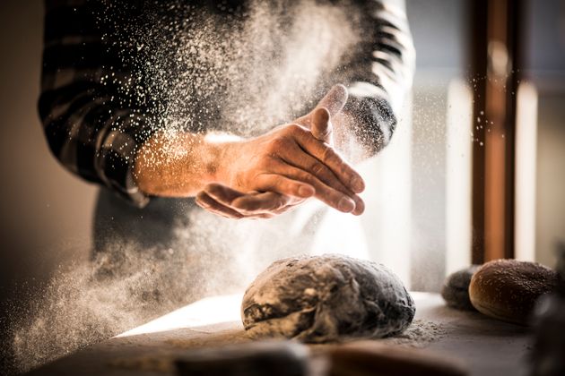 Man preparing black burger buns in kitchen