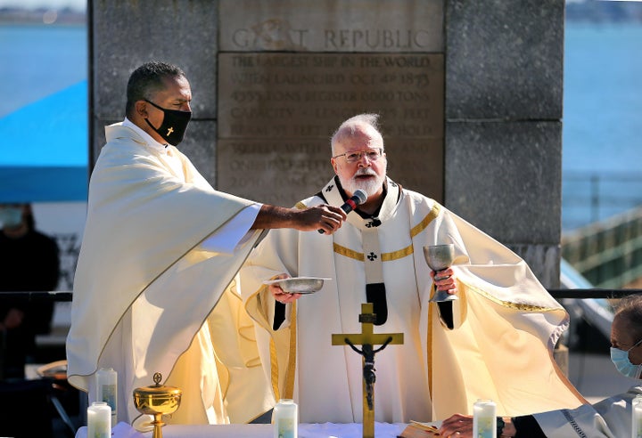 Rev. Oscar Pratt, left, holds the microphone as Cardinal Sean O'Malley speaks during a Mass for Racial Healing in South Boston on June 13, 2020.