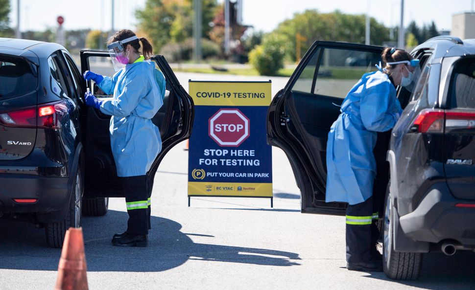 Paramedics administer nasal swabs at a drive through, pop-up COVID-19 test centre outside the Canadian Tire Centre, home of the NHL's Ottawa Senators, in Ottawa on Sept. 20, 2020.