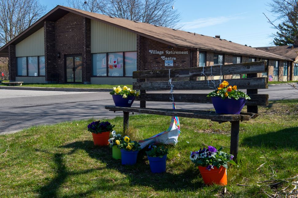 Flowers sit on a bench in front of Orchard Villa care home in Pickering, Ont. on April 27, 2020. Outbreaks of COVID-19 in long-term-care homes have hit residents, health workers, and their families hardest.