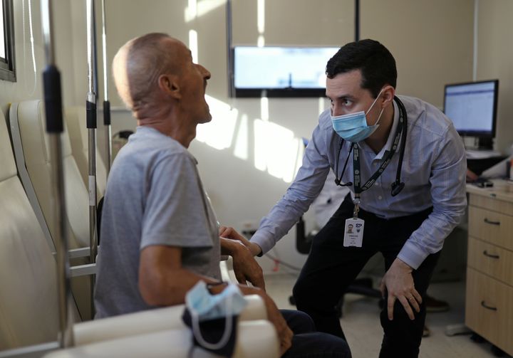 Vinicius Molla, a hematologist and volunteer of the clinical trial of Oxford Covid-19 vaccine, examines a patient at a consulting room in Sao Paulo, Brazil July 9.