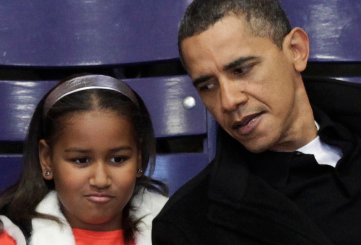 Then-President Barack Obama talks to his daughter Sasha during a Howard University basketball game in 2010, around the time he was coaching her Sidwell Friends school basketball team.