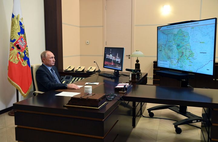 ナゴルノ・カラバフ地域と見られる地図が写し出されたテレビと、ロシアのプーチン大統領