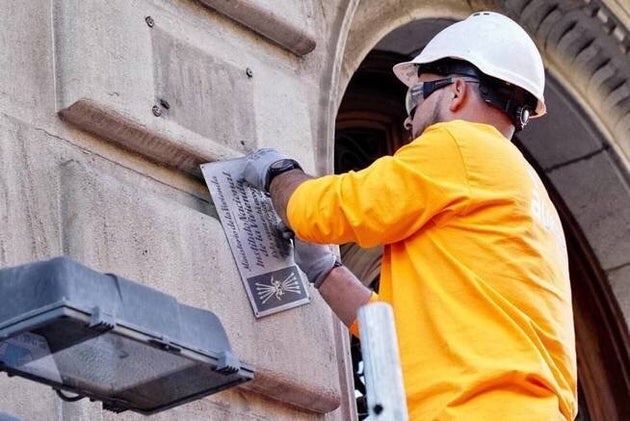 Retirada de la placa de vivienda de protección oficial en un edificio de