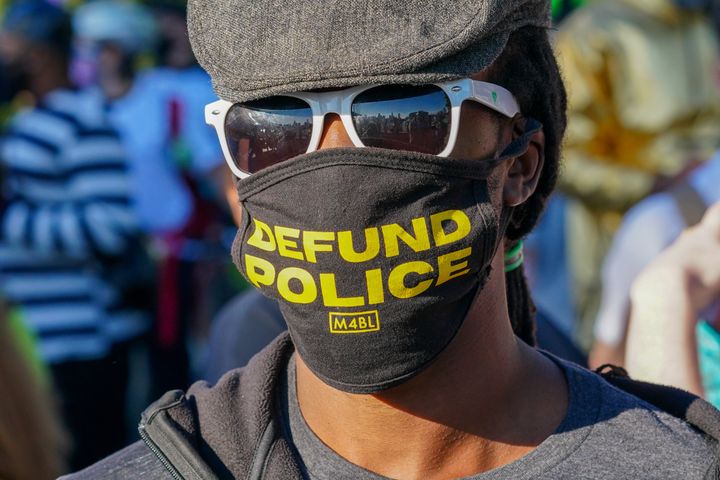 A protester in New York City wears a face mask calling to "Defund Police." The activist cry is now the subject of fierce debate among Democrats.