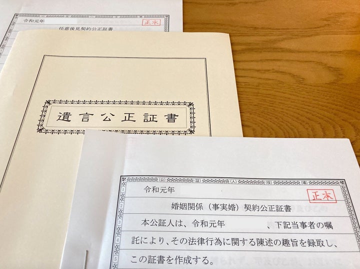 私たち夫婦が作成した「婚姻関係（事実婚）契約公正証書」「遺言公正証書」「任意後見契約公正証書」（手前から。画像の一部を加工しています）