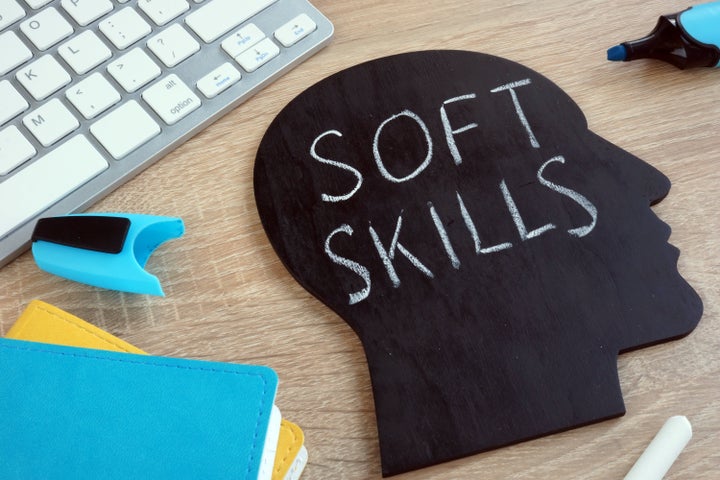 Soft skills written on a blackboard with the shape of a head.