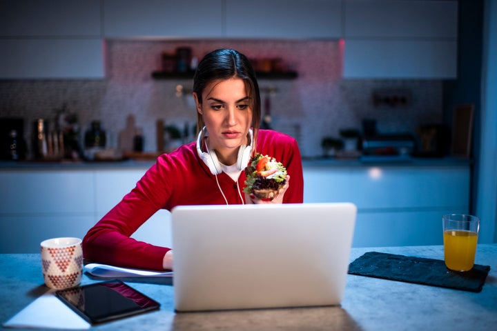 Young female practicing social distancing by working from home during viral outbreak crisis.