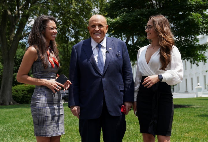 President Donald Trump's personal lawyer Rudy Giuliani poses with OAN correspondent Chanel Rion and his communications director Christianné Allen at the White House in July. Giuliani has been feverishly pushing conspiracy theories in an attempt to overturn Joe Biden's victory, and OAN has worked in lockstep with that effort.