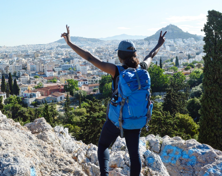 The author in 2017 overlooking Athens, Greece, during the three weeks I traveled carrying only my blue backpack.