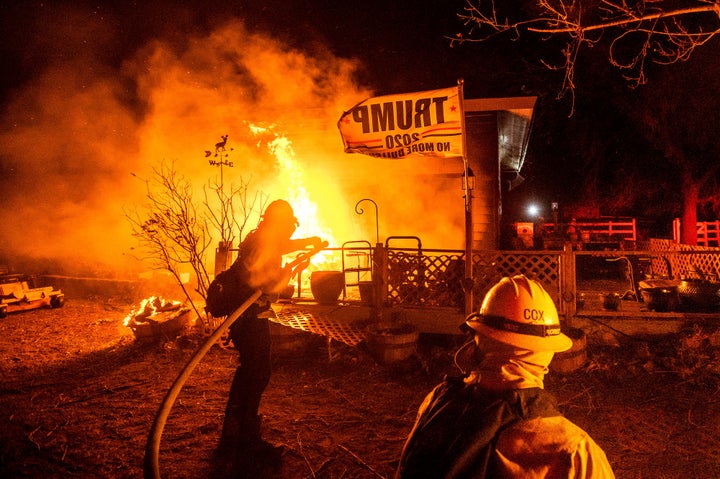 Firefighters spray water on a burning home as the Mountain View Fire tears through the Walker community in Mono County, California., on Wednesday, Nov. 18, 2020.