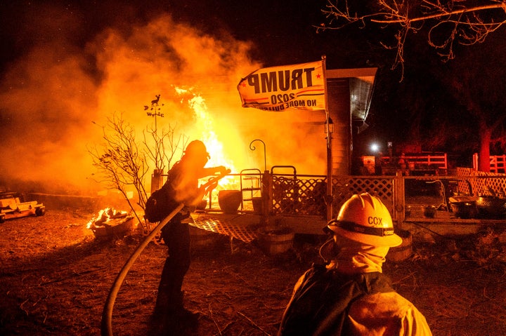 Firefighters spray water on a burning home as the Mountain View Fire tears through the Walker community in Mono County, California., on Wednesday, Nov. 18, 2020.